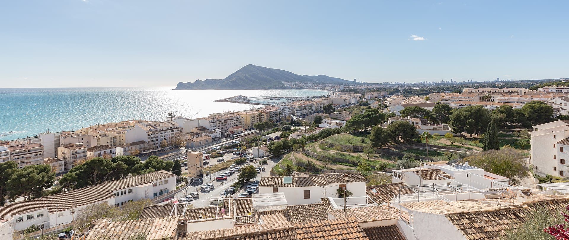 Uitzicht over Altea aan de Costa Blanca: witte huizen met terracottadaken, de baai en in de verte de skyline van Benidorm, één van de plaatsen die op deze pagina vergeleken worden