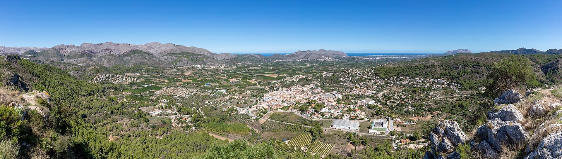 Panoramisch uitzicht op het dorp Orba vanaf El Castellet, met de vallei, de omliggende bergen en de Middellandse Zee in de verte